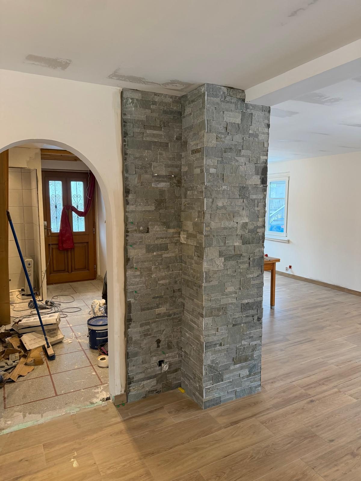 Séjour rénové avec colonne en pierre apparente, réalisation Trend Reno