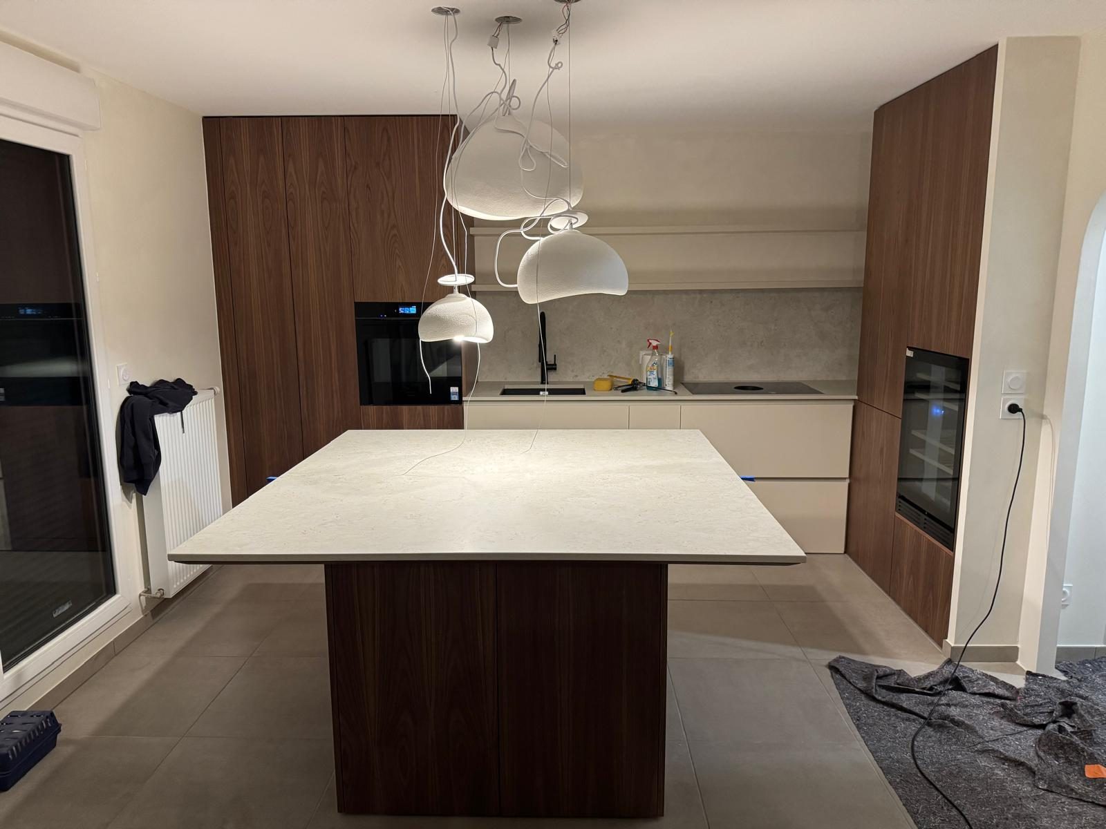 Îlot de cuisine en noyer surmonté de suspensions, réalisation Trend Reno